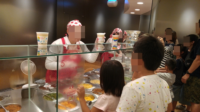 カップヌードルミュージアムのチキンラーメンファクトリーで説明員の方の説明を熱心に聞く子どもたち。